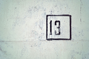 number 13 painted on white house wall