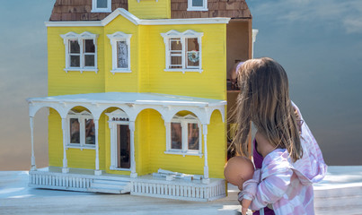 a little girl examines this beautiful old vintage doll house