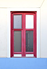 A simple red window in a pale blue wall.