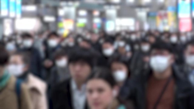 TOKYO, JAPAN - MARCH 2020 : Crowd of people walking at Shinagawa station in morning rush hour. Commuters going to work. People wearing mask to protect from Coronavirus(COVID-19). Blurred slow motion.