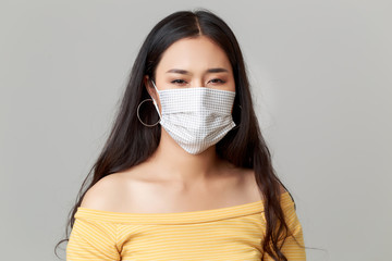 Young Asian woman wearing face mask protecting and quarantine herself form Flu, Covid-19, flu. She is worrying about pandemic.