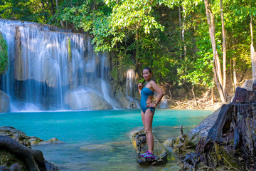 Fototapeta premium Traveler in blue swimsuit stand relax at Erawan Waterfall and natural