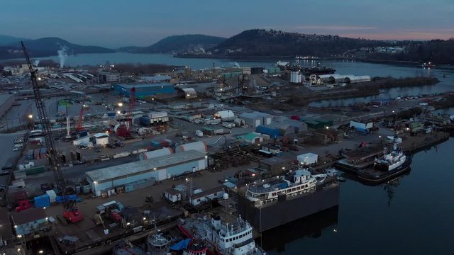 Aerial drone footage of a industrial shipyard and cargo ship loading port in Vancouver, BC, Canada. 4K 24FPS.
