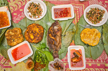 Top view of easy dinner on leaves and mat in the forest