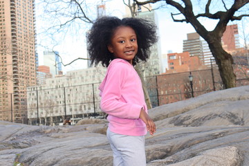Girl on rock hill with city background