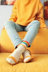 Young woman in socks and sandals at home