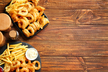 Composition with onion rings and french fries on table