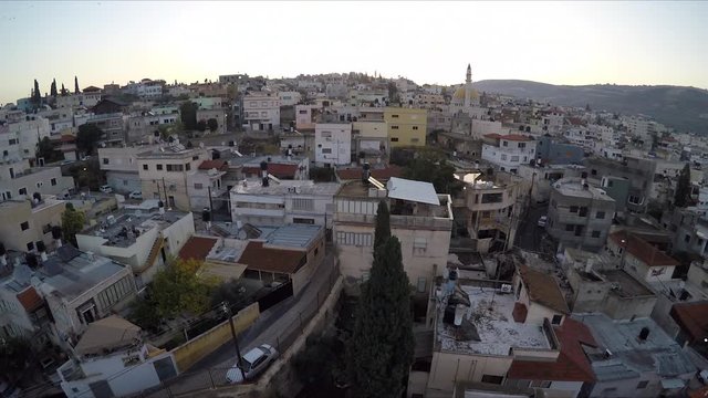 Aerial Rise Up Behind Church to Reveal Cana Israel City Skyline Behind