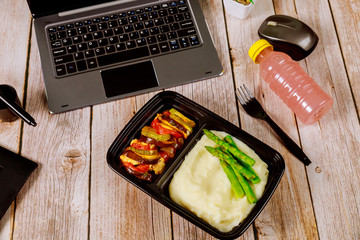 Vegetable ratatouille with mashed potato and asparagus in container for office lunch.