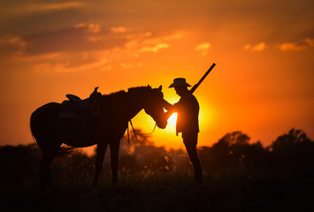 Fototapeta na wymiar Cowboy silhouette And horses in the evening, sunset