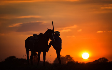 Fototapeta na wymiar Cowboy silhouette And horses in the evening, sunset