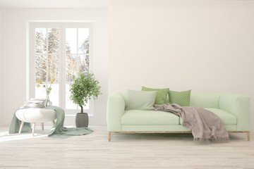 Modern living room in white color with sofa and winter landscape in window. Scandinavian interior design. 3D illustration