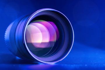 Fototapeta na wymiar The camera lens with blue backlight. Optics. Horizontal macro photo