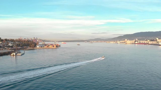 Aerial drone footage of a containers shipyard and cargo ship loading port with boats in the harbor of Vancouver, BC, Canada. 4K 24FPS.