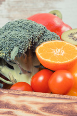 Fresh fruits with vegetables in rustic box as food containing healthy minerals and vitamins