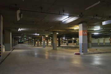 Empty parking interior at night. Parking garage at eight floor.