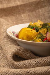 vVegetable salad in a white ceramic bowl on a background of coarse fabric. Close up.egetable salad, village