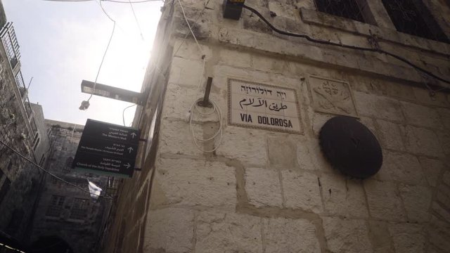 Pivoting shot of the Via Dolorosa street sign marking where Jesus Christ carried the cross in Jerusalem, Israel.