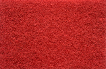 Red background with fleecy texture like Scotch Brite.
