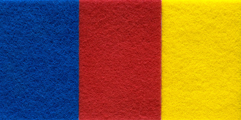 Fototapeta premium Red-blue-yellow background with a fleecy Scotch Brite texture. Close-up.