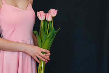 bouquet of pink tulips in women's hands