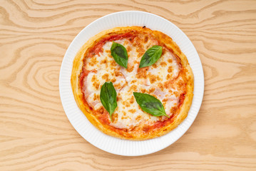 italian pizza on the wooden background, top view