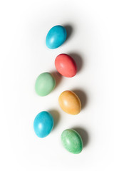 a group of Easter eggs of different colors on a white background