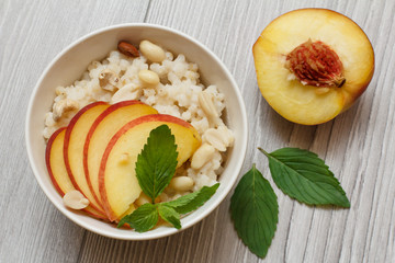 Sorghum salad with nuts and fresh peach on gray boards.