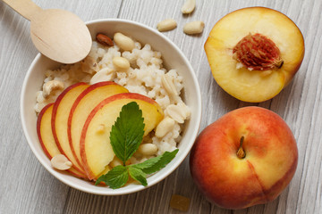 Sorghum salad with nuts and fresh peach on gray boards.