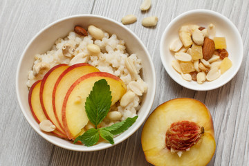 Sorghum salad with nuts and fresh peach on gray boards.
