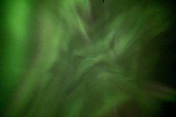 Obraz na płótnie Canvas Looking up into Aurora Borealis Northern Lights Yukon Territory Canada with bright green dancing bands across the northern wilderness sky with tourism, travel, tour, road trip views.