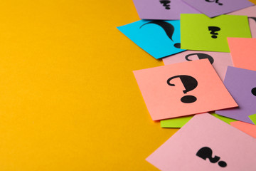 Paper cards with question marks on yellow background, closeup. Space for text