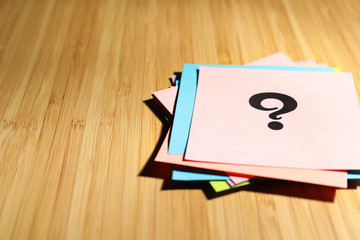 Paper cards with question mark on wooden background, closeup. Space for text