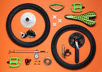 Set of different bicycle tools and parts on orange background, flat lay