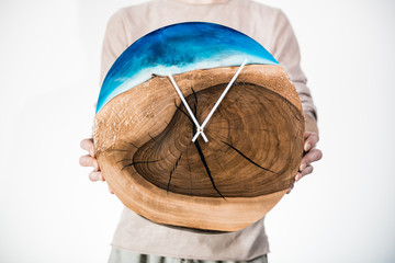 A modern classic wooden watch filled with epoxy resin in the style of LOFT. Man with clock on white background.