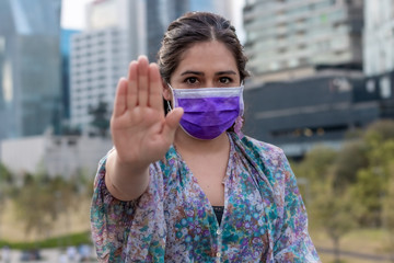 Young woman with mask for respiratory protection. with hand putting a stop to Coronavirus disease