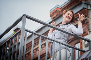 Brunette funny pretty girl on roof in Central part of old city. Walk in downtown. Portrait of a girl on the street