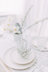 Obraz na płótnie Canvas Coral and white printing in concept. Light interior of the photo Studio. White wedding table decor.