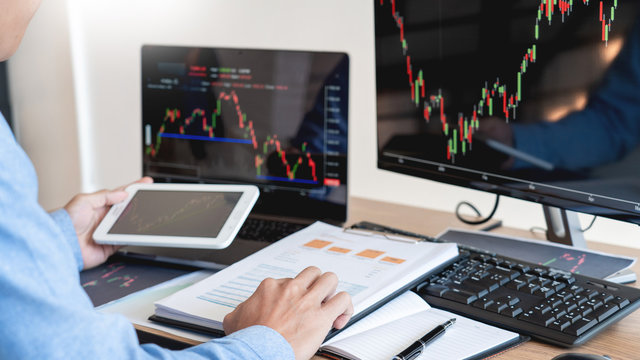 Working business man, team of broker or traders talking about forex on multiple computer screens of stock market invest trading financial graph charts data analysis.