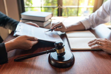 Lawyer working with client discussing contract papers with brass scale about legal legislation in courtroom, consulting to help their customer