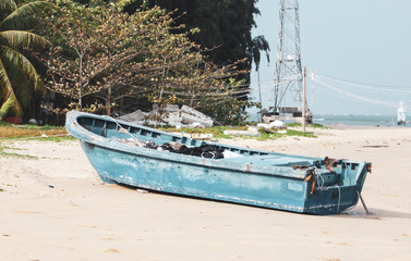 Old blue boat on the sandy shore