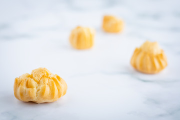 Delicious eclair vanilla cream, choux dough filled with a cream, homemade bakery on white marble background for snack eating concept