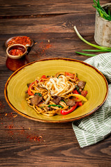 Noodles with slices of meat vegetables in a beautiful plate