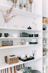 Kitchen design, white wooden shelf with various household items, decorative elements, modern interior, cooking, bright kitchen, minimalism, cozy home, accessories, food, vase, decor, lifestyle