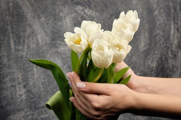 Postcard. Seven white tulips on a grey background. Space for text