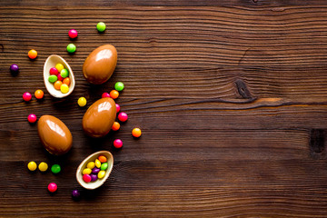 Chocolate eggs - Easter symbol - frame on dark wooden background top-down copy space