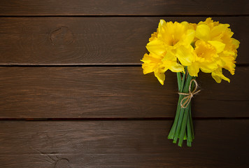 yellow daffodils on dark wooden surface