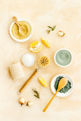 Clay mask, natural facial cosmetic set with herbals on brown background - top view