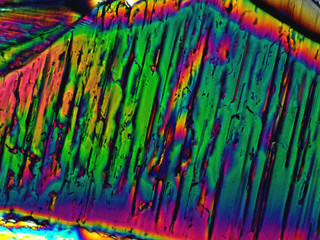Crystal layer on microscope object glass, seen in polarized light. This causes random unforeseeable color effects.