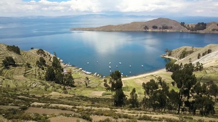 Aerial view over Isla del Sol, looking at the waters of Lake Titicaca - aerial lift up
